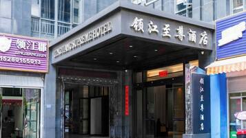 A hotel entrance with a covered entrance area and signage in a foreign language.