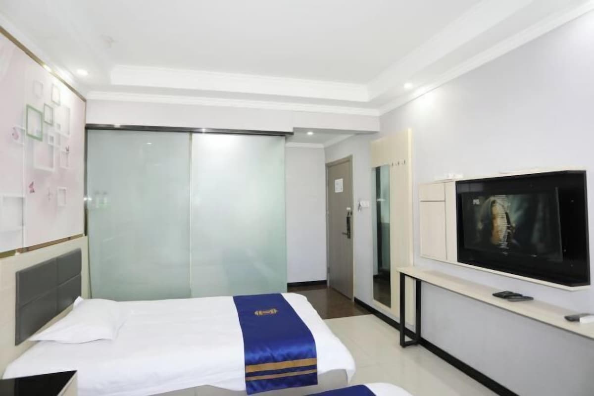 A hotel room with a bed, a television, and a wardrobe.
