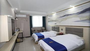 A hotel room with two beds, a desk, a chair, a TV, and a painting on the wall.