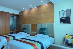 A hotel room with two beds, wooden headboards, a mirror, and a wall-mounted picture.