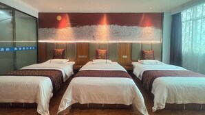 Et hotelværelse med tre senge, et stort vægmaleri og et stort vindue.