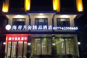 Un hotel con un letrero llamativo que muestra el nombre y el número de teléfono.