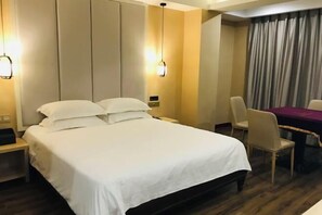 A hotel room with a large bed, a desk, and a chair. - Hai'an Yueshe Boutique Hotel (Yueqing)