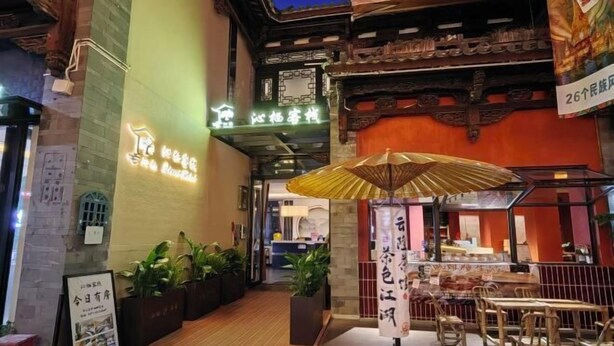 A traditional Chinese restaurant with wooden architecture, a wooden deck, and indoor seating. - Qinqi Inn (Kunming)