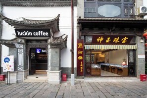 A traditional Chinese building with a coffee shop entrance and a jewelry store. - Qinqi Inn (Kunming)