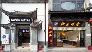 A traditional Chinese building with a coffee shop named 'luckin coffee' and a restaurant with a sign in Chinese characters. - Qinqi Inn (Kunming)