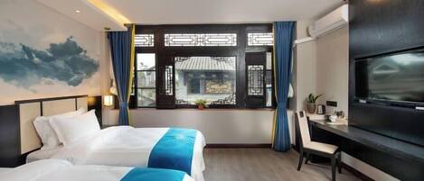 Habitación de hotel con dos camas, un escritorio, un televisor y un ventanal con diseño tradicional chino.