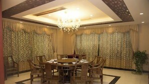 Un comedor con una mesa redonda, varias sillas y una araña.