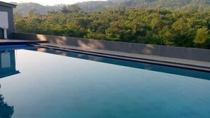 Una piscina con vista a una ladera boscosa.