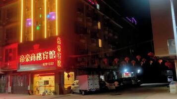 A building with illuminated signage and a parked truck outside.