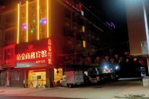 A building with illuminated signage and a parked truck outside. - Fengkai Dihao Business Hotel (Fengkai)