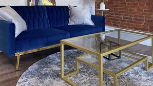A modern living room with a blue sofa, a glass coffee table, and a brick wall. - Free Parking•Historic Charmer completely renovated (Pittsburgh)