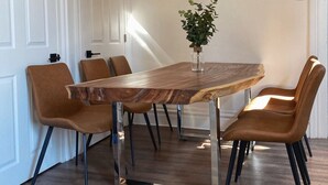 A dining area with a wooden table and six chairs, a potted plant, and a white door. - Free Parking•Historic Charmer completely renovated (Pittsburgh)