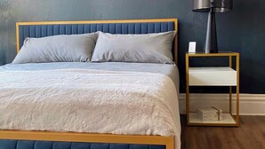 A bedroom with a bed, bedside table, and lamp. - Free Parking•Historic Charmer completely renovated (Pittsburgh)