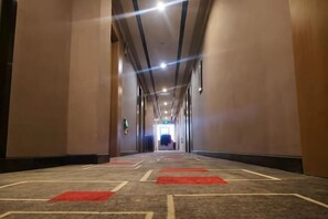 A long, narrow hallway with carpeted floors and red carpet runners, leading to a door at the end. - Shankee Chain Hotel (Longli Laobanjie Pedestrian Street) (Longli)