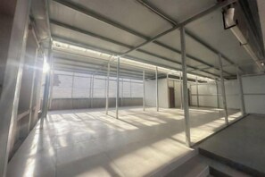 A spacious, industrial-style room with metal beams and a high ceiling. - Lisi Dandun Hotel (Chongqing)