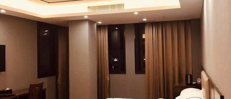 A modern hotel room with a bed, a desk, and a chair.