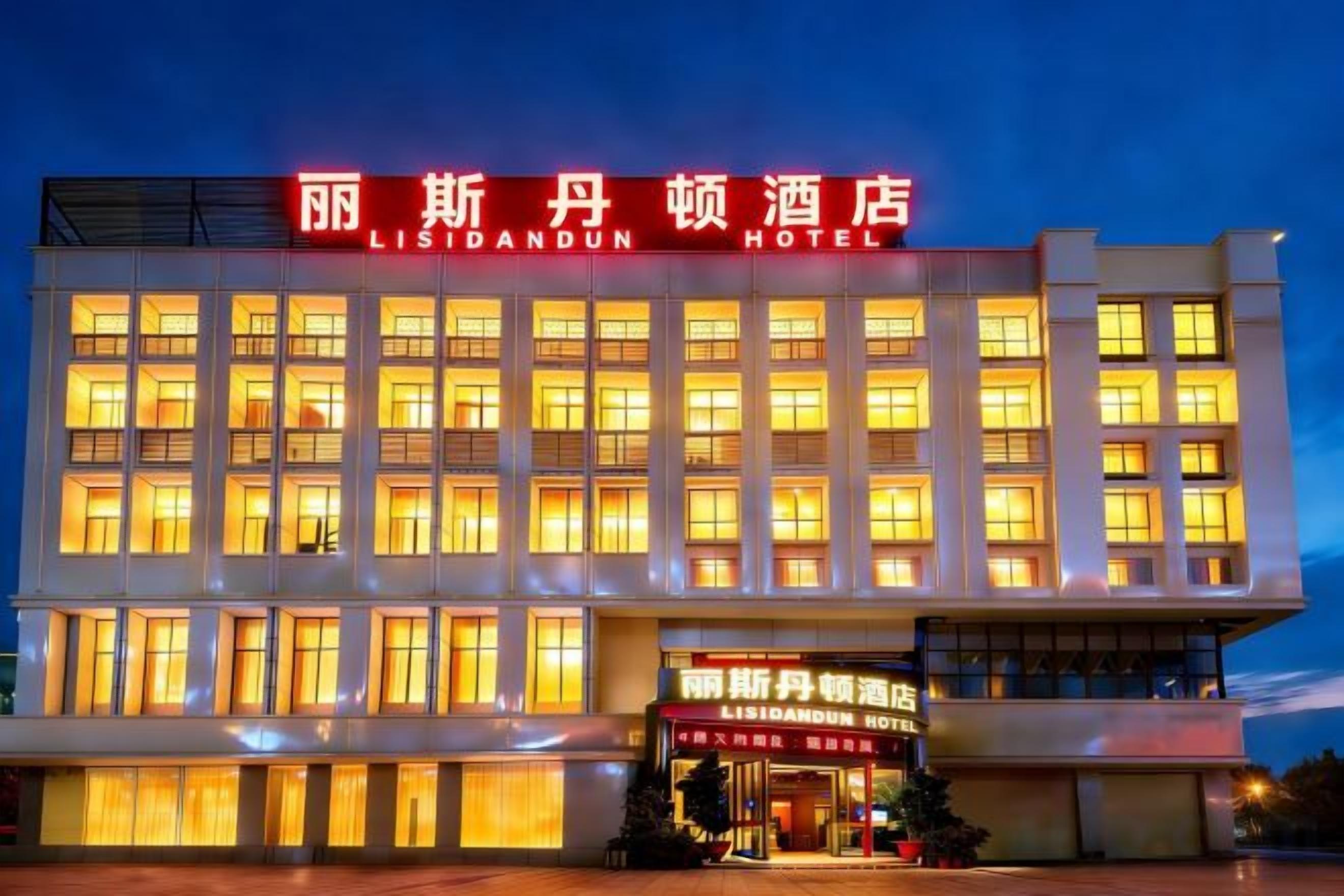 A hotel with a prominent sign in a foreign language, multiple floors, and a well-lit facade.
