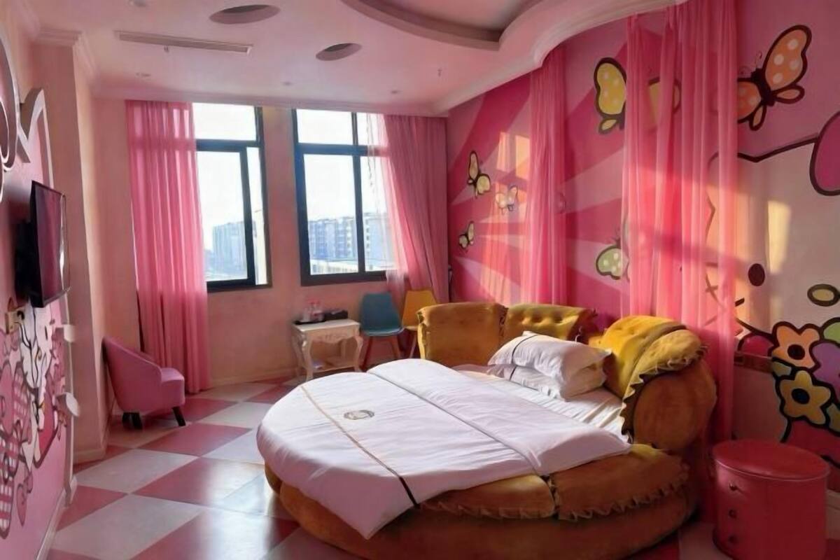 A bedroom with a bed, a chair, a small table, and a window.