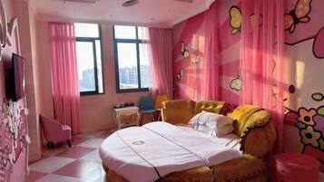 A bedroom with a bed, a chair, a small table, and a window.