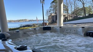 A hot tub with a view of a river and a bridge in the background.