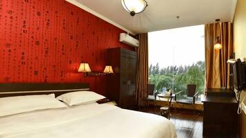 A hotel room with a large bed, two bedside lamps, a TV, and a view of the outdoors.