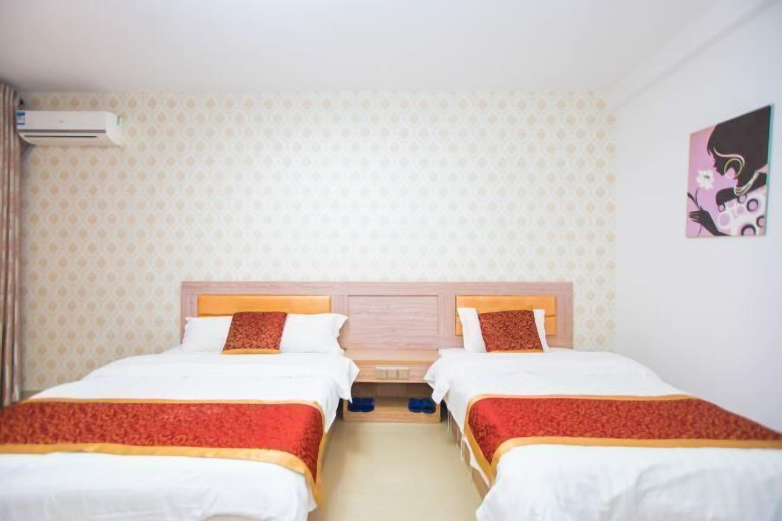 Une chambre d’hôtel avec deux lits, une tête de lit en bois, un papier peint à motifs et un tableau au mur.