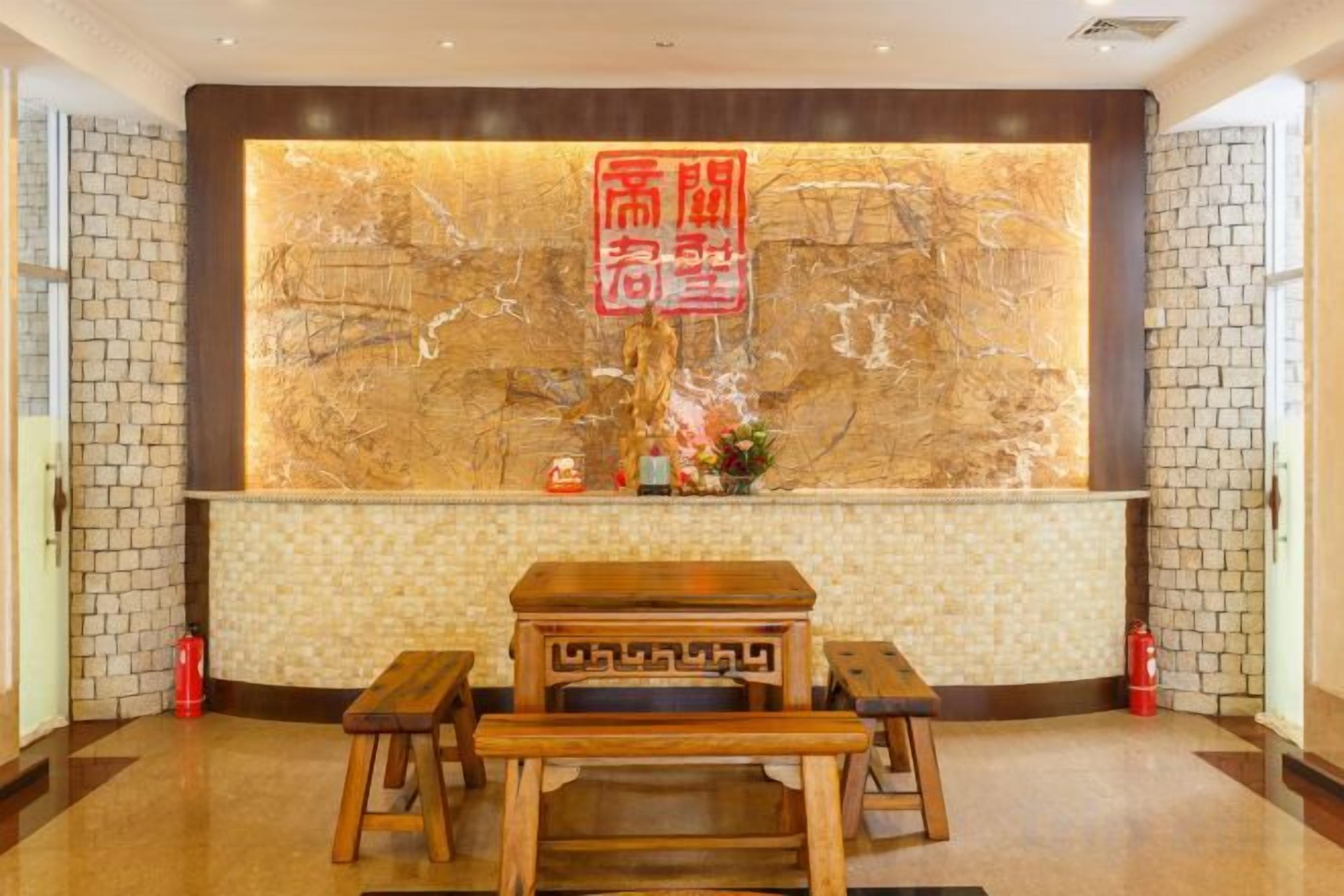 A reception area with a marble wall, a reception desk, and a wooden bench.