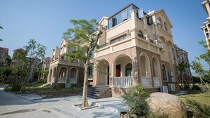 A multi-story residential building with a balcony, arched windows, and a stone facade. - Huaxia Hotel (Dongshan County)