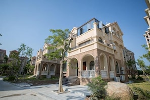 A multi-story residential building with a balcony, arched windows, and a stone facade. - Huaxia Hotel (Dongshan County)