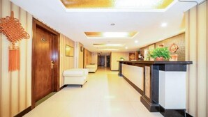A hotel lobby with a reception desk, a white sofa, and a wooden door. - Duyun Jinpeng Hotel (Duyun Dashiban Ancient Street Store) (Duyun)