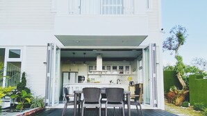 Une maison à deux étages dotée d’un balcon et d’un patio.