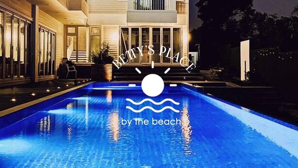 Une grande maison moderne avec une piscine en premier plan.