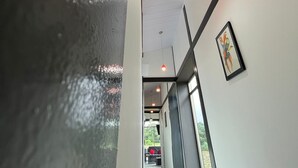 A corridor with a wet floor, ceiling lights, and a framed picture on the wall.