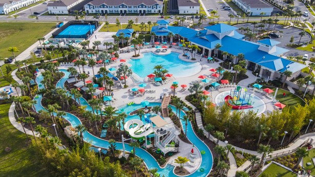 Ein Resort mit einem großen zentralen Pool, mehreren Wasserrutschen und zahlreichen Liegestühlen und Sonnenschirmen.