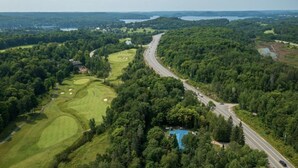 Eine Vogelperspektive eines Golfplatzes, begleitet von einer Straße.