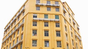 A multi-story yellow building with a sign in Chinese characters. - Qiaoxiang Hotel (Fuqing)
