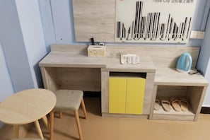 Una pequeña cocina americana con un armario amarillo, una mesa y una silla.