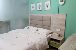 A bedroom with a bed, bedside table, and a wall clock. - Orange Apartment (Zhongshan)