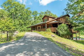 Eine Holzlodge mit verdeckter Veranda und einer Schotterauffahrt zum Eingang.