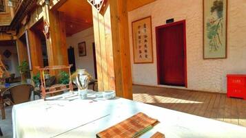 Un edificio de madera tradicional con un comedor que incluye una mesa, palillos y una tetera.