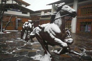 Un patio con piso de piedra y varias estatuas de caballos.