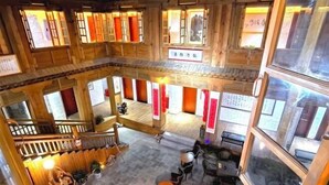 A multi-level wooden interior with a central open area, seating arrangements, and signage.