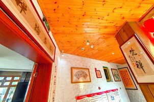 Una habitación con techo de madera, obras de arte enmarcadas en las paredes y una puerta visible.