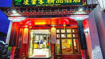 L’entrée d’un hôtel présentant des éléments architecturaux traditionnels chinois, notamment des décorations et des panneaux indicateurs élaborés.