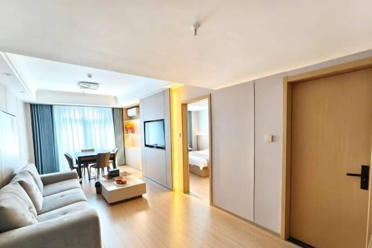 Een moderne hotelkamer met een bank, een eettafel en een televisie.