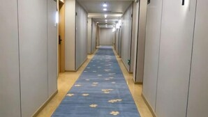 A long hallway with a blue carpet, doors on both sides, and a light-colored floor. - Quanzhou Xingang Hotel (Quanzhou)