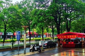 A street scene with a red canopy, a scooter, and a car parked on the side. - Quanzhou Xingang Hotel (Quanzhou)