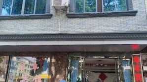 A building with a brick facade, large windows, and a sign with Chinese characters. - Hotels Hua Feng (Shangrao)