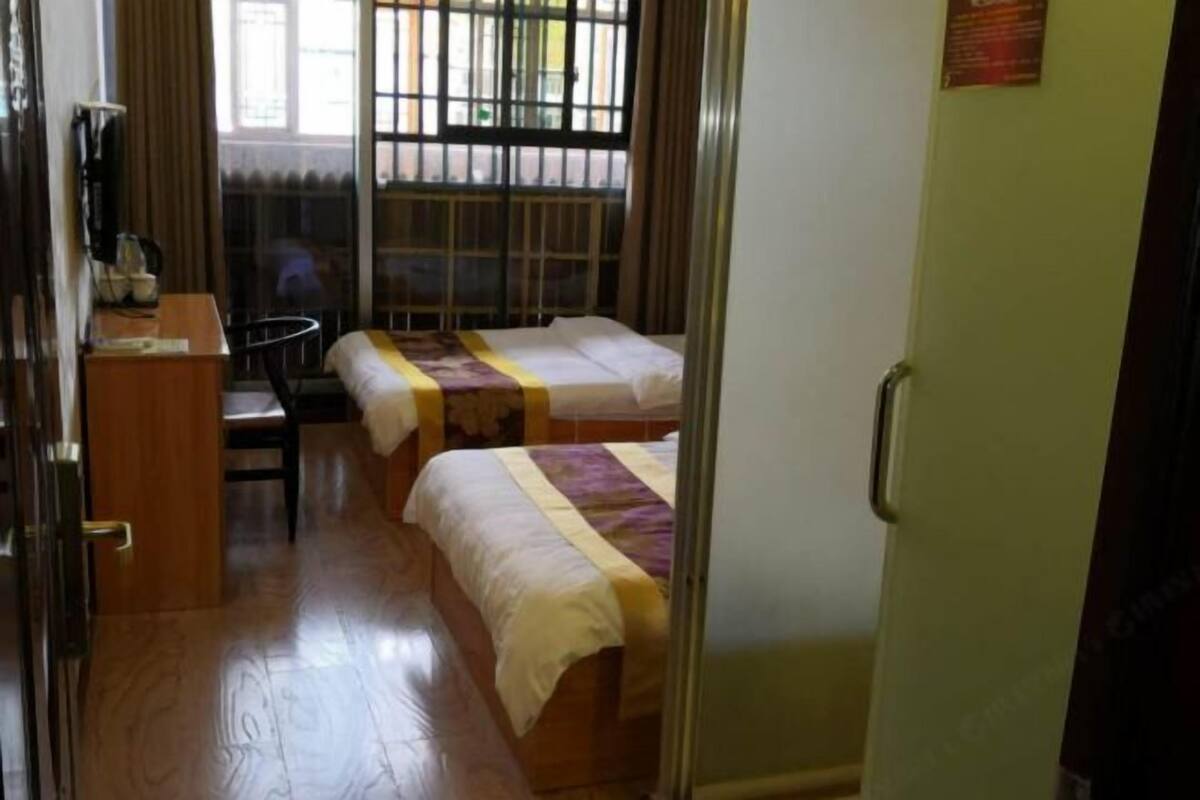 Una habitación con dos camas, un escritorio y una silla.